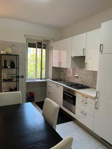 a kitchen with white cabinets and a table and a refrigerator at Red house in Monteverde - Zen Real Estate in Rome