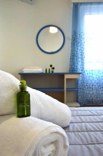 a green bottle of soap sitting on top of a bed at EstellApartments in Athens