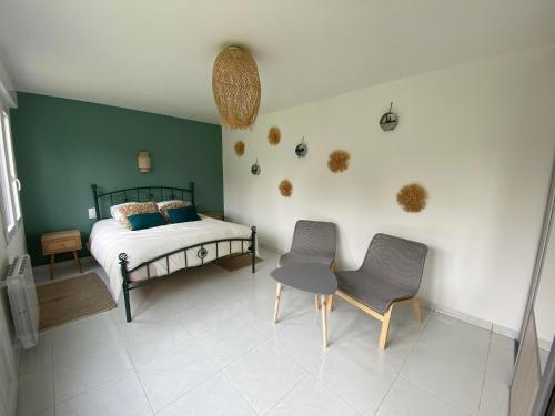 une chambre avec un lit, deux chaises et une table dans l'établissement Maison cosy en plein coeur de Ouistreham, à Ouistreham