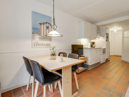 cocina y comedor con mesa y sillas en Apartment Halina - 100m from the sea in Western Jutland by Interhome, en Fanø