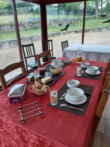 a table with a red table cloth with food on it at Domaine Lagardelle Rocamadour in Rocamadour