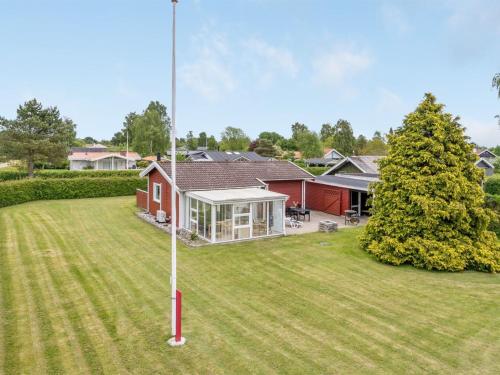 une maison avec une cour et une maison rouge dans l'établissement Holiday Home Cenia - 450m from the sea in SE Jutland by Interhome, à Neder Lysabild