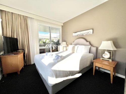 231 Lovely North Facing 2 Bedroom metres to Main Beach tesisinde bir odada yatak veya yataklar