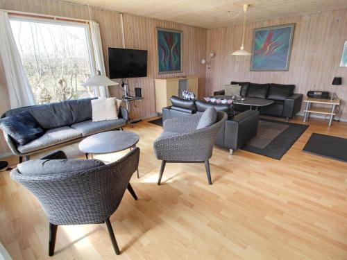 a living room with a couch and a table and chairs at Holiday Home Svanhild - 1-2km from the sea in Western Jutland by Interhome in Fanø