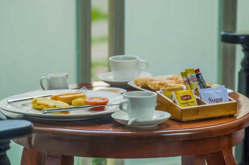 einen Tisch mit zwei Teller Essen und Kaffeetassen in der Unterkunft The Night Hotel in Siem Reap