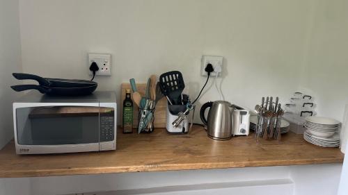 a counter top with a microwave and some utensils at Eagle’s Nest in Hilton