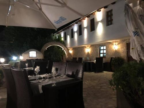 a restaurant with tables and chairs in front of a building at Hotel-Restaurant Kriva Ćuprija in Mostar