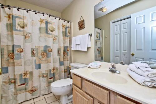 a bathroom with a sink and a toilet and a shower curtain at Bonhomme Richard East in Gulf Shores