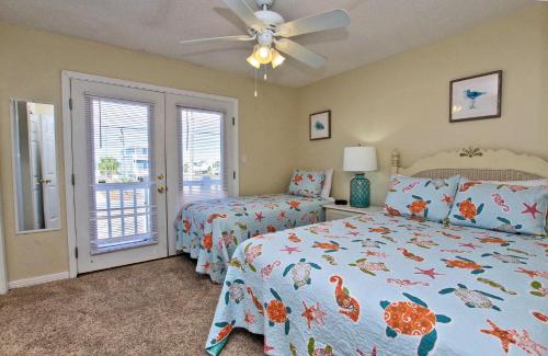 a bedroom with two beds and a ceiling fan at Bonhomme Richard East in Gulf Shores