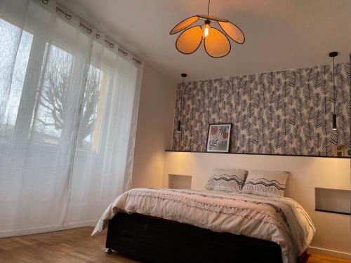 a bedroom with a bed and a large window at Appartement du lion in Belfort