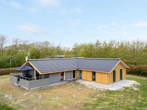 a house with a metal roof on a yard at Holiday Home Arona - 1-5km from the sea in Western Jutland by Interhome in Fanø