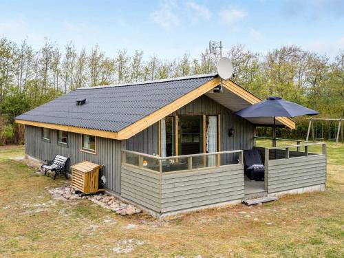 a small house with an umbrella on top of it at Holiday Home Arona - 1-5km from the sea in Western Jutland by Interhome in Fanø