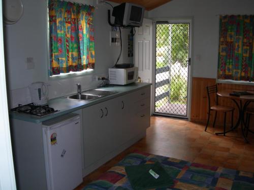 a kitchen with a sink and a microwave on a counter at Riverside Tourist Park in Rockhampton