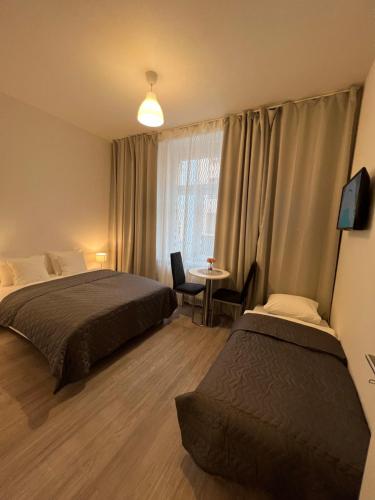 - une chambre avec 2 lits, une table et une fenêtre dans l'établissement Maria Apartment Liben, à Prague