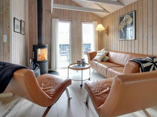 a living room with leather furniture and a fireplace at Holiday Home Casandra - 600m from the sea in Western Jutland by Interhome in Fanø