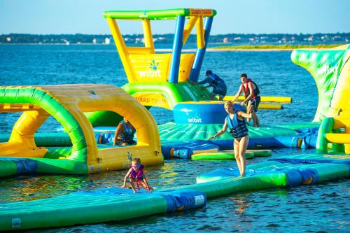 a group of people playing on inflatables in the water at Portofino Tower 3 Unit 1609 in Pensacola Beach