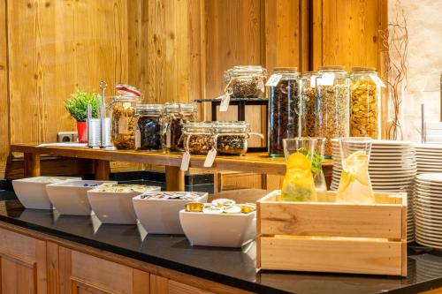 a counter with a bunch of bowls and plates of food at Sporthotel Cristall in Fulpmes