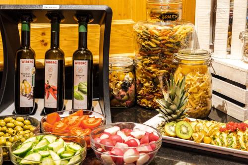 a table with bottles of wine and bowls of food at Sporthotel Cristall in Fulpmes