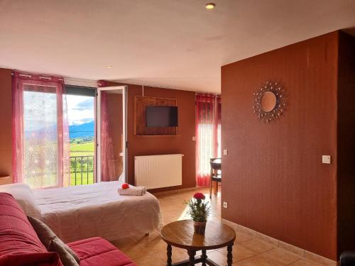 a bedroom with a bed and a couch and a tv at Le Catalan - Hôtel et appartements in Mont-Louis