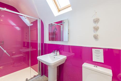 a pink bathroom with a sink and a shower at Lord Galloway 34 with Hot Tub in Newton Stewart