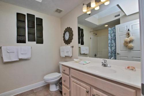 La salle de bains est pourvue d'un lavabo, de toilettes et d'un miroir. dans l'établissement Crystal Shores West 1007, à Gulf Shores