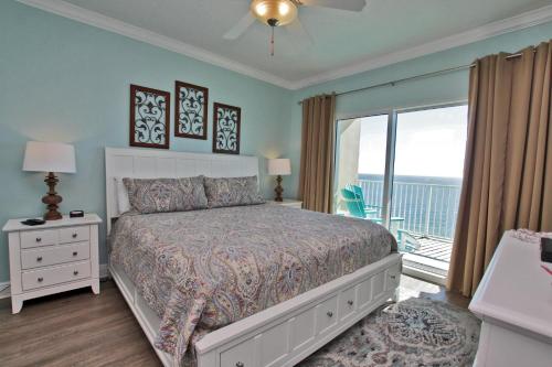 a bedroom with a large bed and a balcony at Crystal Shores West 1007 in Gulf Shores