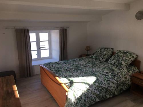 une chambre avec un grand lit et une fenêtre dans l'établissement Maison de village et jardin , à Mornac sur Seudre, à Mornac-sur-Seudre