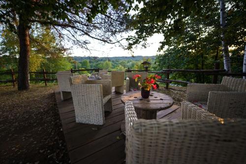 una terrazza in legno con sedie e un tavolo con fiori di FUTURE IS NATURE PLAYGROUND a Sala Biellese