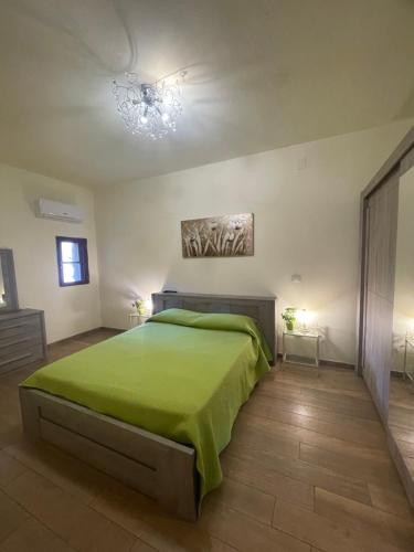 Un dormitorio con una cama verde y una lámpara de araña. en Roy House, en Alghero