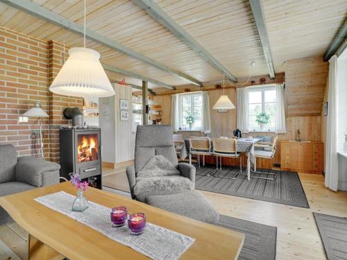 uma sala de estar com uma mesa e uma lareira em Holiday Home Hakun - 4km from the sea in Western Jutland by Interhome em Rømø Kirkeby