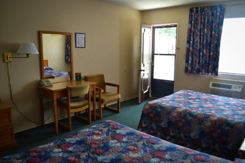 a hotel room with two beds and a television at Lighthouse Motel in Walkerton