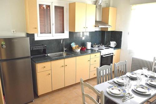 uma cozinha com uma mesa e um frigorífico de aço inoxidável em EstellApartments em Atenas