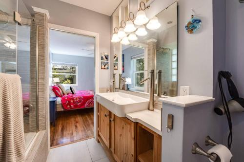 een badkamer met een wastafel, een spiegel en een bad bij Bluebird Bungalow in Jacksonville