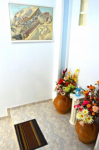 a room with two vases with flowers on the floor at EstellApartments in Athens