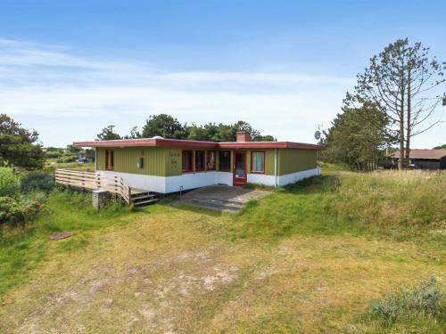 een huis op een heuvel met een grasveld bij Holiday Home Sweni - 800m from the sea in Western Jutland by Interhome in Fanø