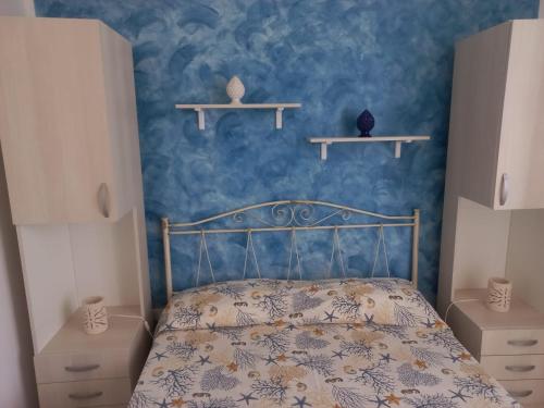una camera con un letto con una parete blu di Casa Simo a Lido Marini