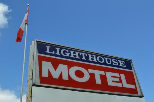 a light house motel sign next to a flag at Lighthouse Motel in Walkerton