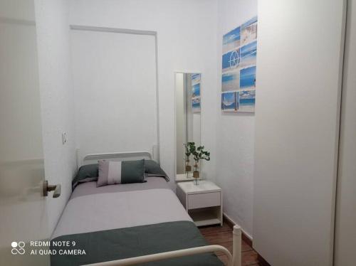 Dormitorio pequeño con cama y mesa en Apartamento playa, en La Pobla de Farnals