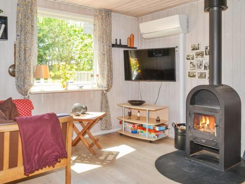 een woonkamer met een houtkachel. bij Holiday Home Karlotta - 2-2km from the sea in Western Jutland by Interhome in Bolilmark