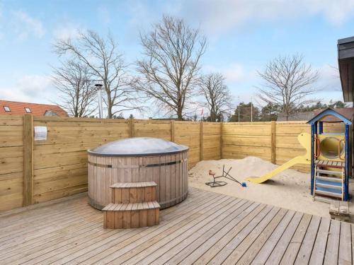 a backyard with a wooden fence and a playground at Holiday Home Christiern - 4-5km from the sea by Interhome in Kongsmark