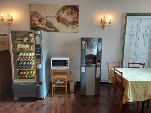 ジェノヴァにあるFamily Hotel Balbiの冷蔵庫2台、テーブル(テーブル付)が備わる客室です。