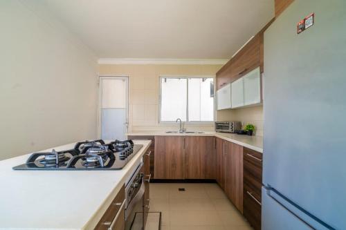 a kitchen with a stove and a white refrigerator at Hotel Cabañas Villa Roca, Rodadero in Santa Marta