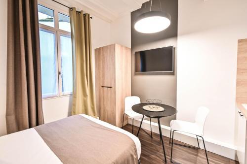 a bedroom with a bed and a table and chairs at Les cles du 27 Paris in Paris