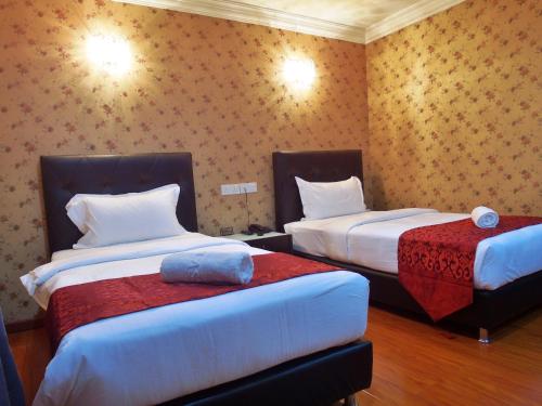 A bed or beds in a room at Classic Kinabalu Hotel