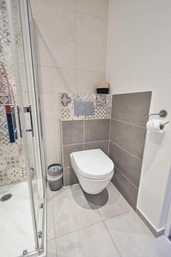 a small bathroom with a toilet and a shower at Les cles du 27 Paris in Paris