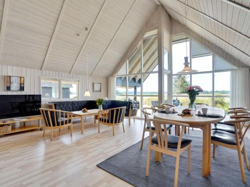 a living room with a table and chairs at Holiday Home Allin - 1km from the sea in Western Jutland by Interhome in Mølby