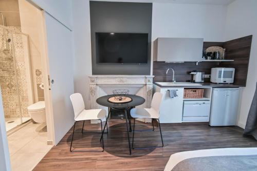 a small kitchen with a table and chairs in a room at Les cles du 27 Paris in Paris
