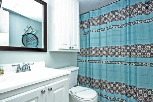 a bathroom with a toilet and a shower curtain at Gulf Shores Surf & Racquet 715A in Gulf Shores