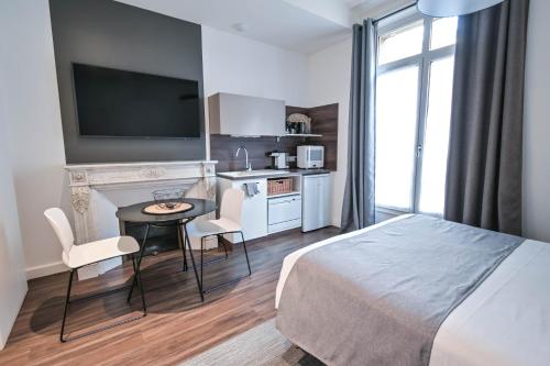a hotel room with a bed and a table and a kitchen at Les cles du 27 Paris in Paris