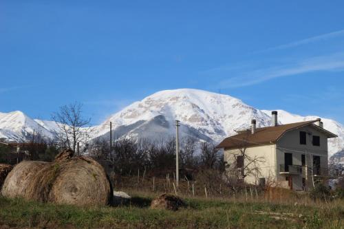 a snow covered mountain with a house and hay at Prati di Maja B&B in Miglianico